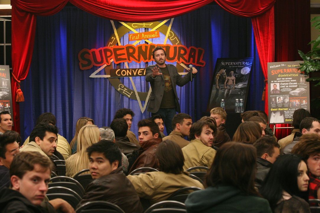 Sam und Dean landen durch Chuck (Rob Benedict, stehend) bei einer "Supernatural"-Convention. Doch als echte Geister auftauchen, müssen sie handeln,... - Bildquelle: Warner Bros.