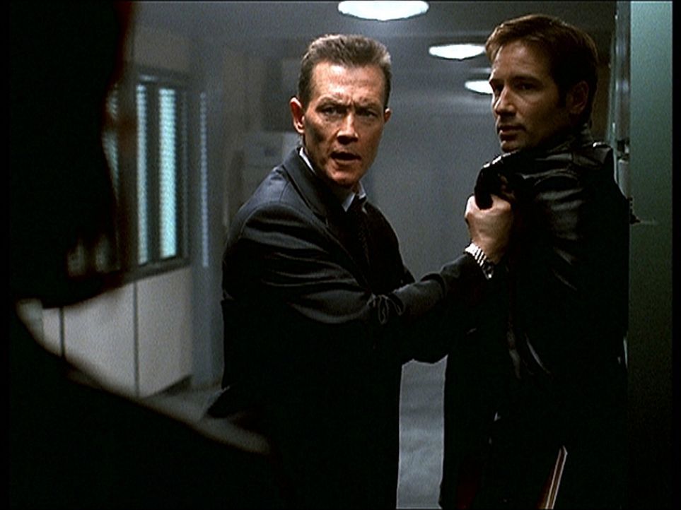 Doggett (Robert Patrick, M.) vertraut Mulder (David Duchovny, r.) nicht mehr und bedroht ihn mit einer Waffe. - Bildquelle: TM +   2000 Twentieth Century Fox Film Corporation. All Rights Reserved.