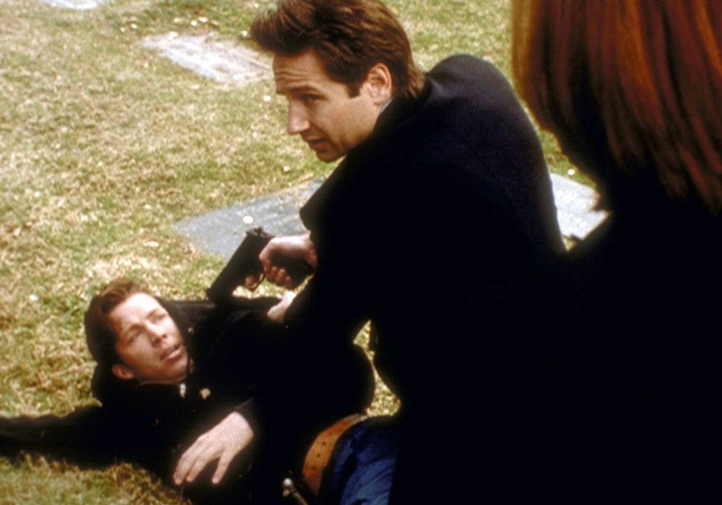 Mulder (David Duchovny, r.) hält den Friedhofsgärtner (Casey C. O'Neill) für den Täter einer Reihe von Morden, bei denen den Opfern das Herz entfern... - Bildquelle: TM +   2000 Twentieth Century Fox Film Corporation. All Rights Reserved.