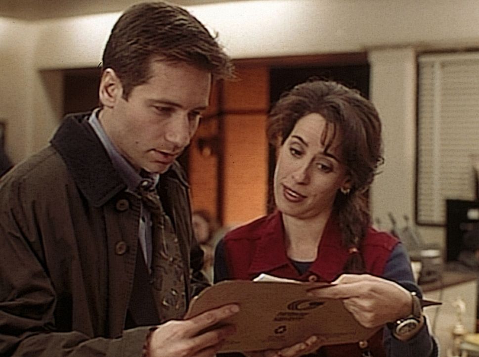 Die Polizistin Lazard (Maggie Wheeler, r.) zeigt Mulder (David Duchovny, l.) den Autopsiebericht eines vor neun Jahren auf ungeklärte Weise ermordet... - Bildquelle: TM +   2000 Twentieth Century Fox Film Corporation. All Rights Reserved.