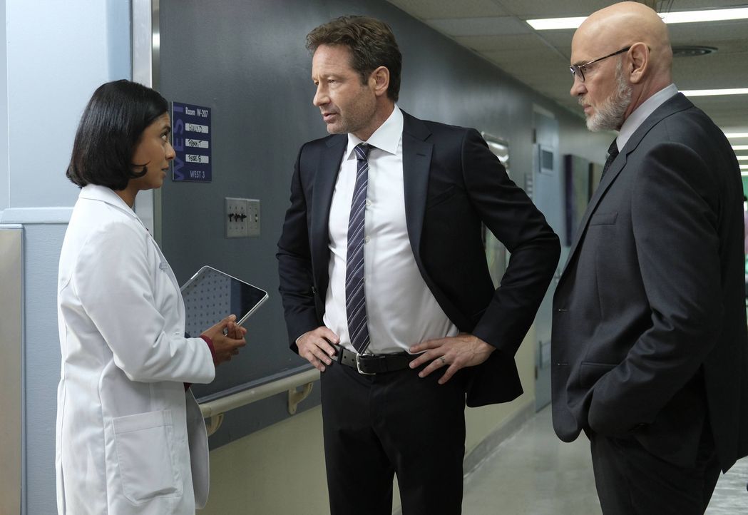 Als Dr. Joyet (Anjali Jay, l.) Mulder (David Duchovny, M.) und Skinner (Mitch Pileggi, r.) zeigt, welche extremen Hirnaktivitäten bei Scully vor sic... - Bildquelle: Robert Falconer 2017 Fox and its related entities. All rights reserved. / Robert Falconer