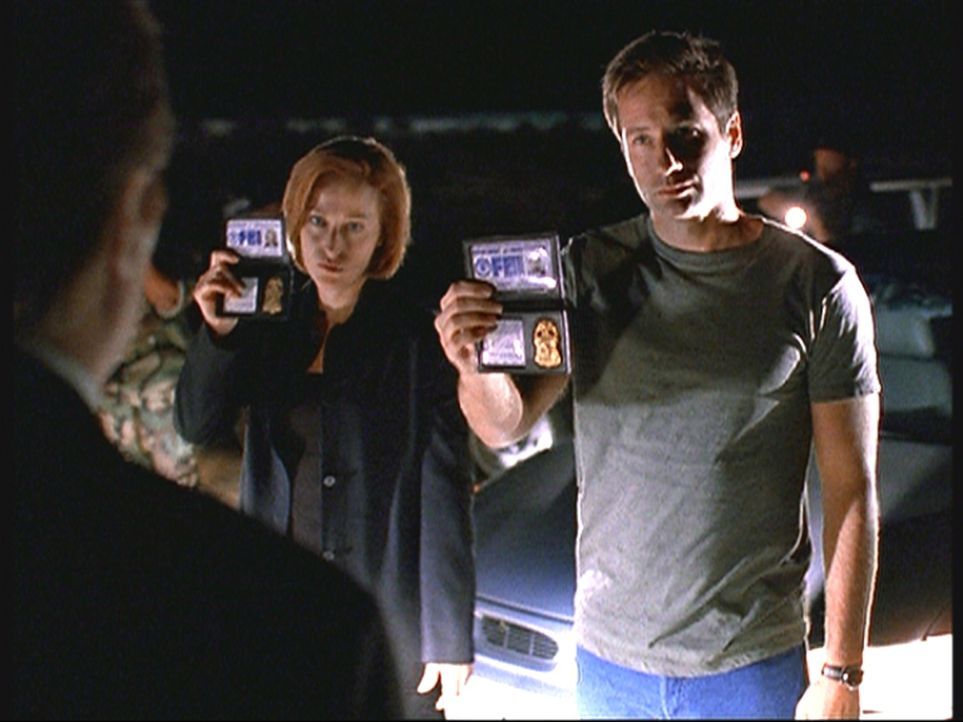 Mulder (David Duchovny, r.) und Scully (Gillian Anderson, M.) werden auf dem Highway 375 in Nevada vom Militär gestoppt und müssen sich ausweisen. - Bildquelle: TM +   2000 Twentieth Century Fox Film Corporation. All Rights Reserved.