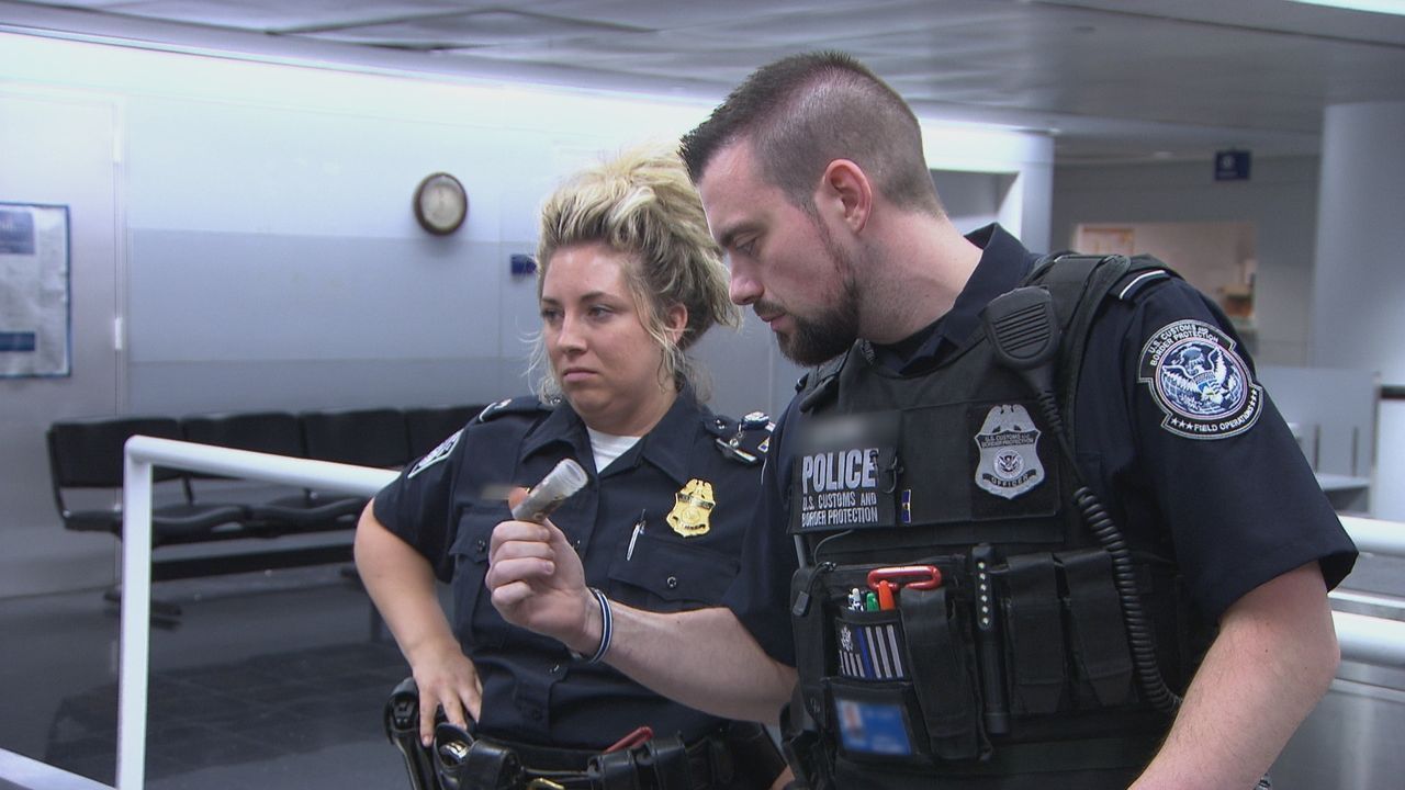 Ein Grenzschützer am Flughafen Boston wird auf einen französischen Reisenden... - Bildquelle: Licensed by Cineflix International