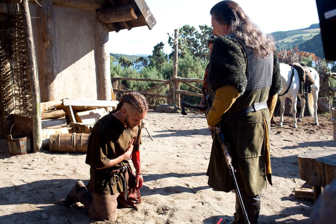 Schwer verletzt ergibt sich Ragnar (Travis Fimmel, l.) seinem Stammesfürsten Earl Haraldson (Gabriel Byrne, r.). Dieser verurteilt ihn sofort zum To... - Bildquelle: 2013 TM TELEVISION PRODUCTIONS LIMITED/T5 VIKINGS PRODUCTIONS INC. ALL RIGHTS RESERVED.