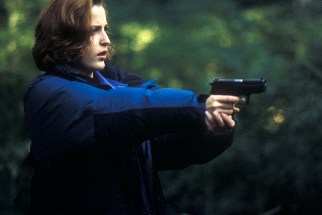 Scully (Gillian Anderson) zielt auf einen unsichtbaren Gegner, den sie zunächst für ein Raubtier hielt. - Bildquelle: TM +   2000 Twentieth Century Fox Film Corporation. All Rights Reserved.