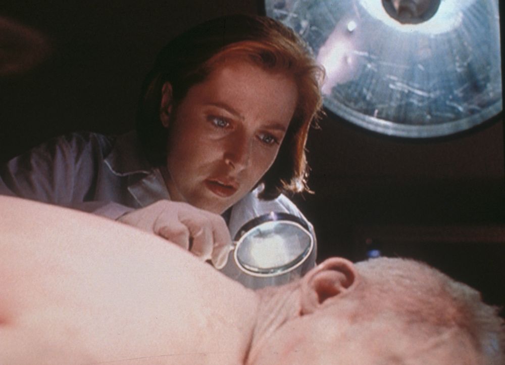 Scully (Gillian Anderson) entdeckt an der Leiche des Erschossenen, dass dem Mann schon Tage vor seinem Tod ein geheimnisvolles Gift in die Wirbelsäu... - Bildquelle: TM +   2000 Twentieth Century Fox Film Corporation. All Rights Reserved.