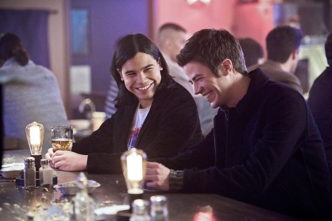 Als Cisco (Carlos Valdes, l.) und Barry (Grant Gustin, r.) in einer Bar angesprochen werden, ahnen sie nicht, wer die hübsche Frau wirklich ist ... - Bildquelle: Warner Brothers.