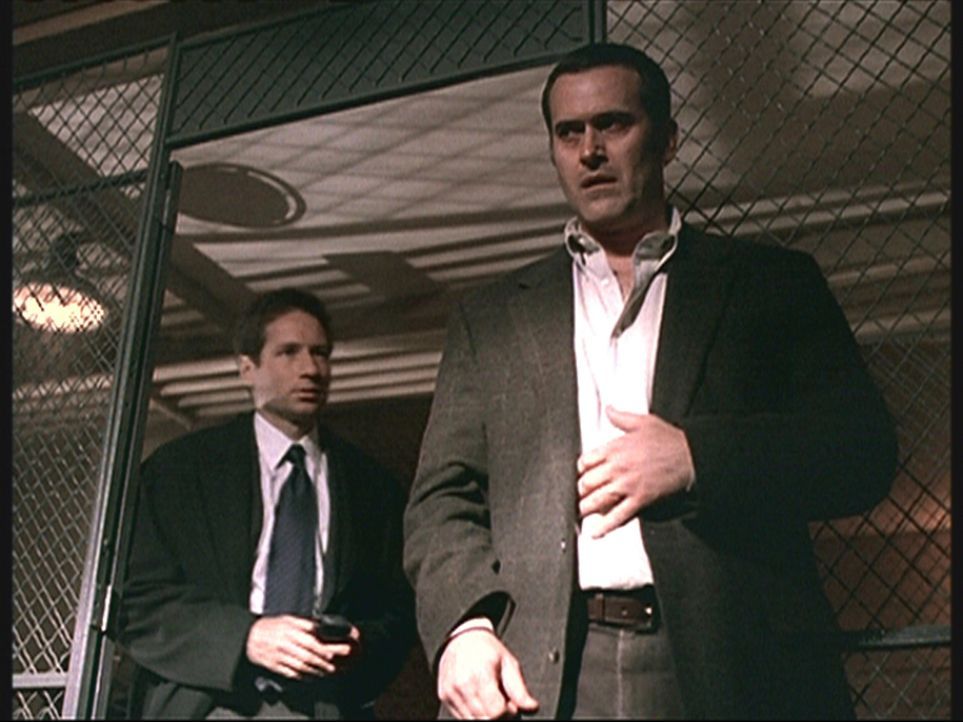 Mulder (David Duchovny, l.) hegt den Verdacht, dass der Versicherungsvertreter Wayne Weinsider (Bruce Campbell, r.) in Wirklichkeit ein Dämon ist. - Bildquelle: TM +   2000 Twentieth Century Fox Film Corporation. All Rights Reserved.