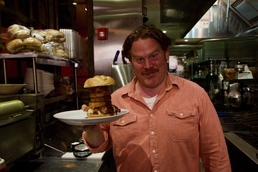 In der "Boston Burger Company" in Boston probiert Casey den leckeren "Killer Bee Burger", der mit gegrillten Zwiebelringen garniert ist. - Bildquelle: 2017,The Travel Channel, L.L.C. All Rights Reserved.