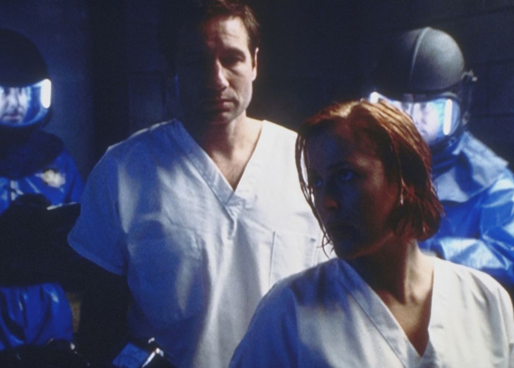 Mulder (David Duchovny, l.) und Scully (Gillian Anderson, r.) sind von angeblichen Mitarbeitern der Seuchenschutzbehörde verhaftet und in ein Militä... - Bildquelle: TM +   2000 Twentieth Century Fox Film Corporation. All Rights Reserved.