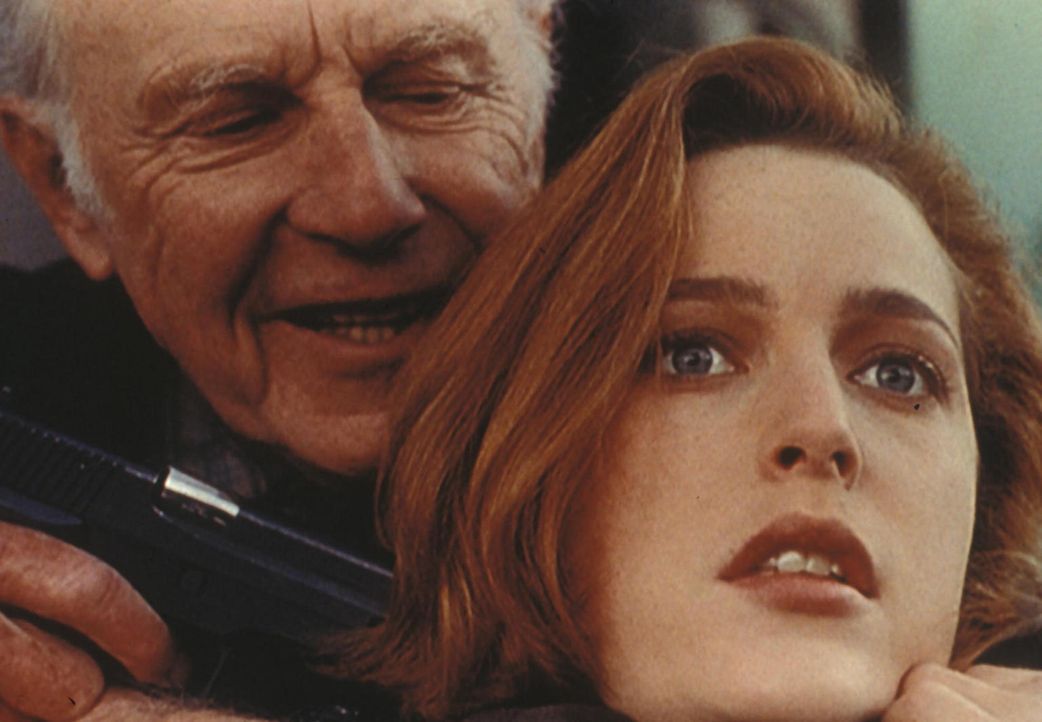 Scully (Gillian Anderson, r.) wird von dem russischen Agenten Vassily Peskow (Jan Rubes, l.) als Geisel benutzt, damit er fliehen kann. - Bildquelle: TM +   Twentieth Century Fox Film Corporation. All Rights Reserved.
