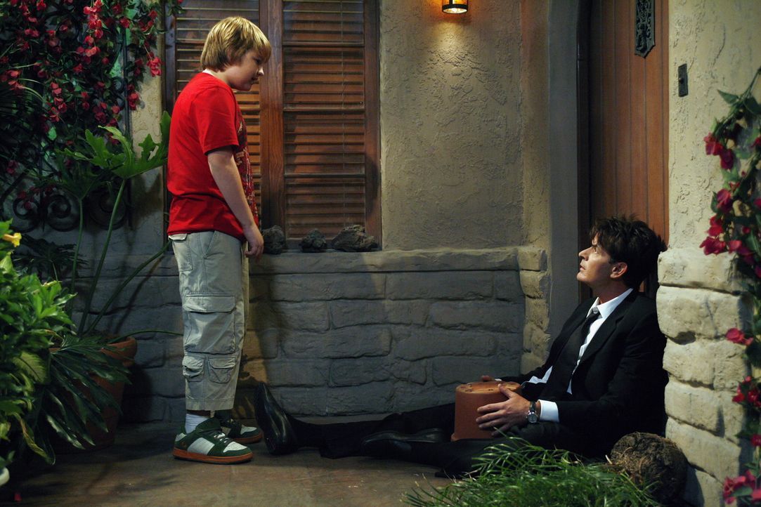Jake (Angus T. Jones, l.) trifft auf seinen Onkel Charlie (Charlie Sheen, r.) vor der Haustür und bemerkt, dass irgendetwas mit ihm nicht stimmt ... - Bildquelle: Warner Brothers Entertainment Inc.