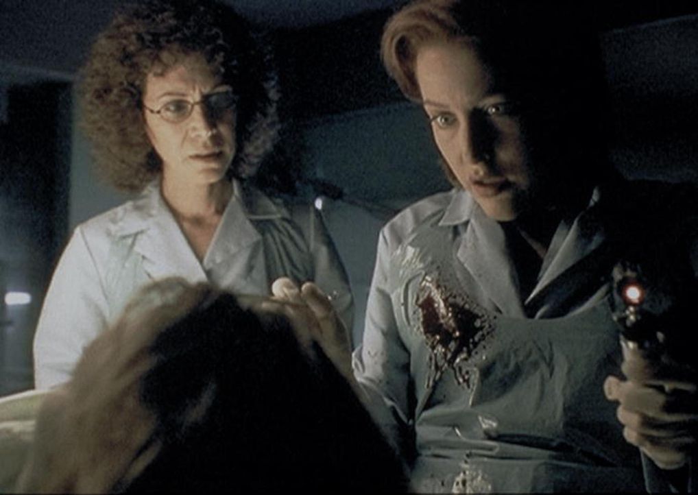 Scully (Gillian Anderson, r.) und die Gerichtsmedizinerin (Mindy Seeger, l.) stellen fest, dass die angebliche Geisel nicht durch eine Polizeikugel... - Bildquelle: TM +   2000 Twentieth Century Fox Film Corporation. All Rights Reserved.