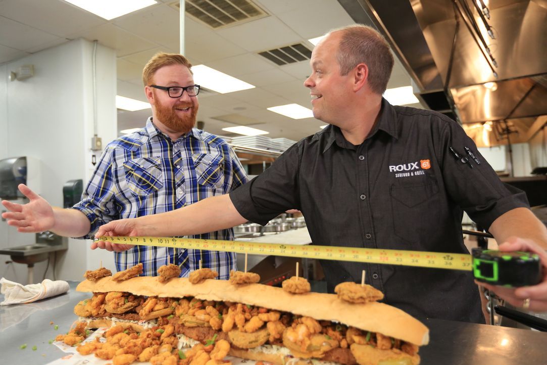 Koch Jason (r.) misst für Josh (l.) gerne noch einmal nach: das "BL-Titan Sandwich" erstreckt sich tatsächlich über einen ganzen Meter. - Bildquelle: 2017,Television Food Network, G.P. All Rights Reserved