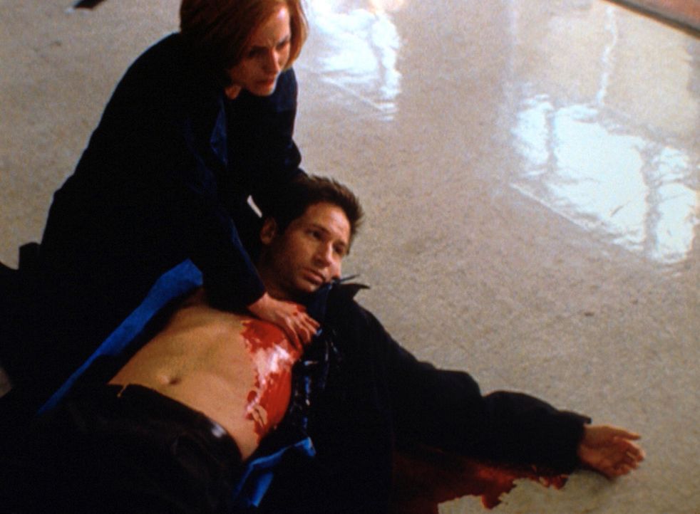 Vergeblich versucht Scully (Gillian Anderson, l.), Mulder (David Duchovny, r.) zu helfen, der von einem Bankräuber angeschossen worden ist. - Bildquelle: TM +   2000 Twentieth Century Fox Film Corporation. All Rights Reserved.