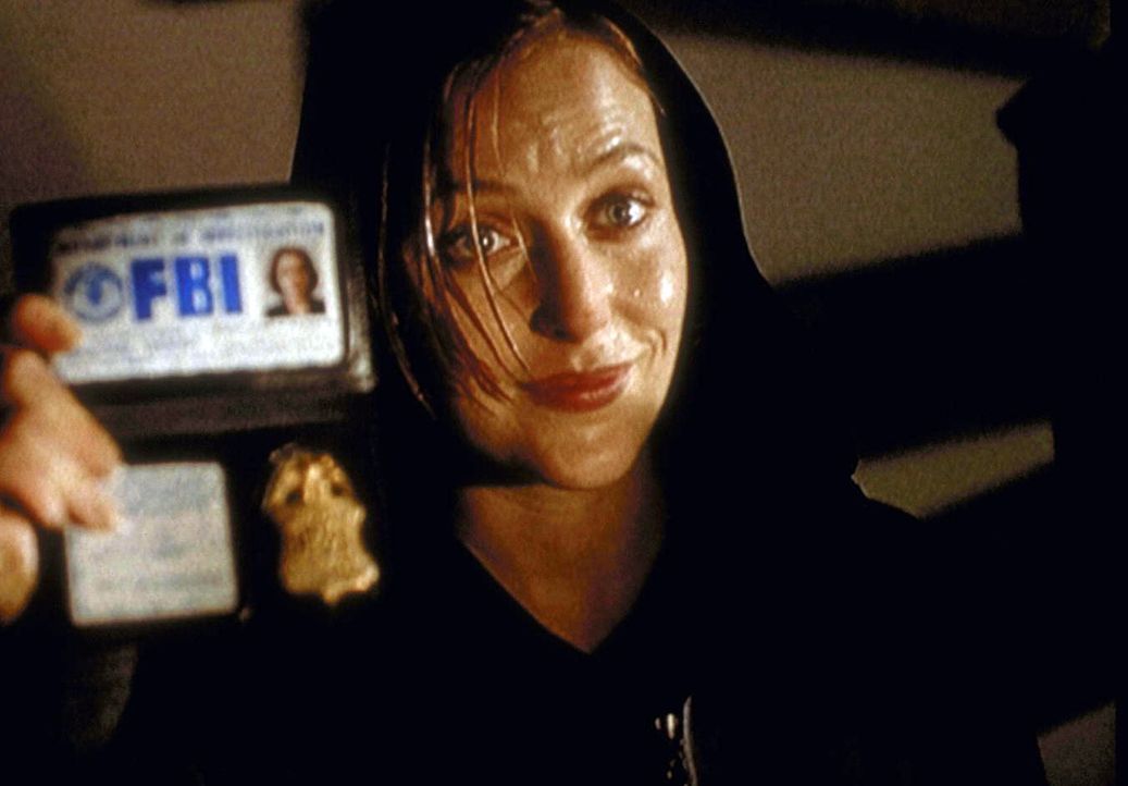 Da ein Polizist ihr nicht glauben will, weist sich Scully (Gillian Anderson) als FBI-Agentin aus. - Bildquelle: TM +   2000 Twentieth Century Fox Film Corporation. All Rights Reserved.