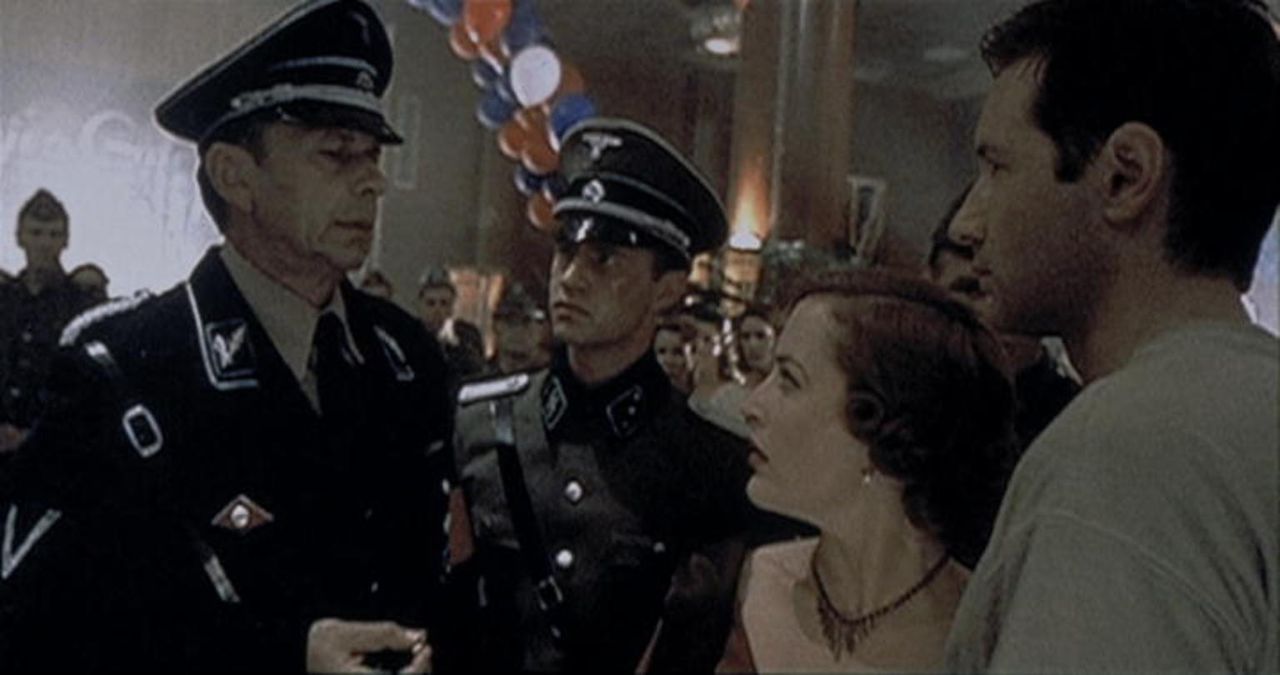 Mulder (David Duchovny, r.) und Scully (Gillian Anderson, 2.v.r.) werden von dem Befehlshaber der Waffen-SS (William B. Davis, l.) auf der "Queen An... - Bildquelle: TM +   2000 Twentieth Century Fox Film Corporation. All Rights Reserved.