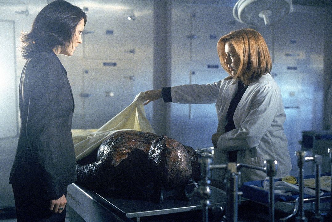 Reyes (Annabeth Gish, l.) und Scully (Gillian Anderson, r.) untersuchen eine Leiche, die angeblich Knowle Rohrer sein soll. - Bildquelle: TM +   Twentieth Century Fox Film Corporation. All Rights Reserved.